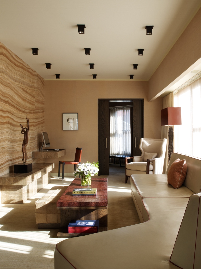 Living room of the penthouse at Roxy Hotel with white leather couch and wood table.